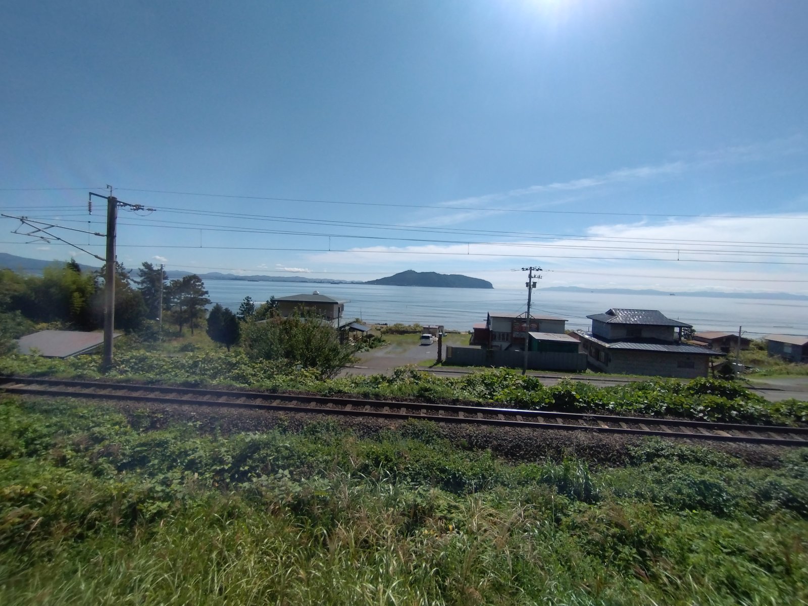 海沿いを走る単線の線路と集落