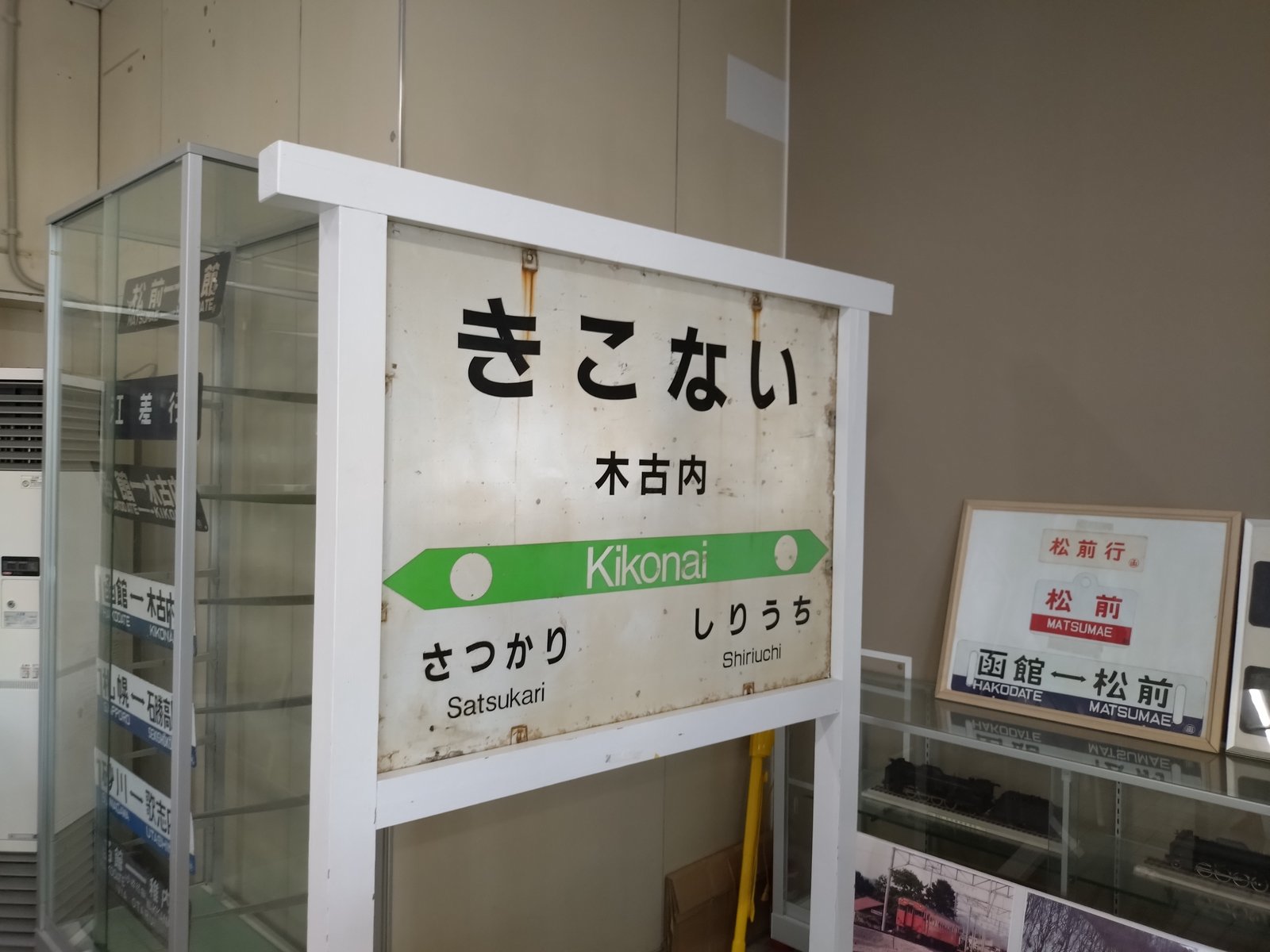 木古内駅に置かれた古い駅名標とガラスケースのサボ